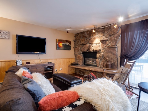 Curl up on the plush sofa with cozy throws and sink into your perfect mountain retreat, where a rustic stone fireplace adds warmth and charm to your relaxing evenings together.