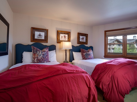 You'll rest easy in this cozy bedroom with plush beds, elegant decor, and a window view that invites natural light to brighten your mornings.