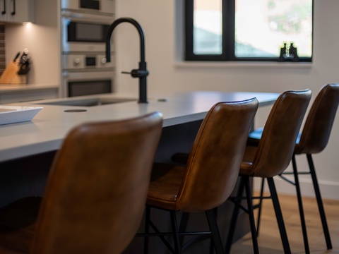 Gather with friends or sip your morning coffee at this sleek kitchen island, where modern design meets everyday comfort in your stylish retreat.