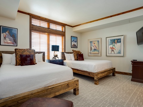 Cozy bedroom with rustic wood beds, vintage ski posters, and classic mountain charm—your perfect retreat after a day on the slopes.