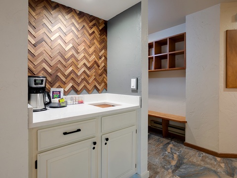 Brew your morning coffee in your private kitchenette with a striking herringbone wood accent wall and ample storage for your convenience.