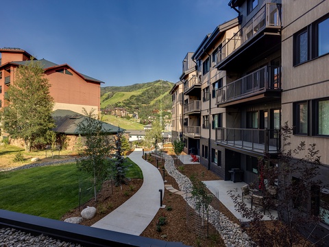 The property nestled in a stunning mountain setting, surrounded by lush green slopes and thoughtfully landscaped grounds with winding pathways perfect for leisurely strolls.