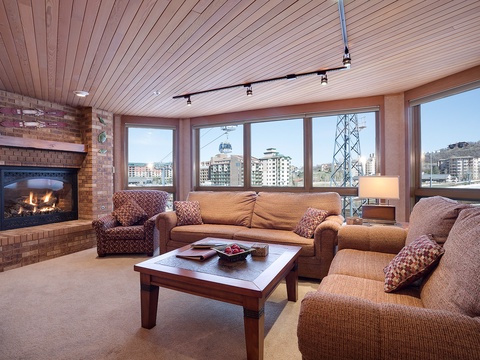 Unwind in your cozy living space, where a crackling fireplace meets breathtaking mountain views—your perfect retreat after a day on the slopes.