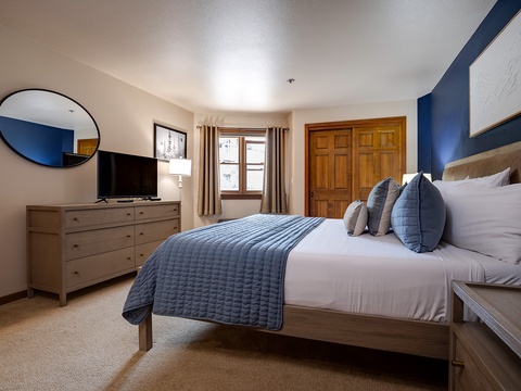 Picture yourself sinking into crisp linens after a day exploring, surrounded by calming blues and warm wood tones. Your private retreat features a plush bed, flatscreen TV, and ample storage for all your getaway essentials.