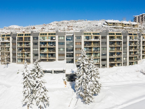 This alpine property sits nestled among snow-covered evergreens with direct ski slope access, surrounded by pristine winter landscapes and mountain village charm.