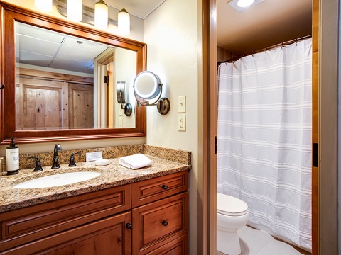 Your private bathroom features granite counters, plush towels, and a well-lit vanity mirror—everything you need to refresh after a day of mountain adventures.
