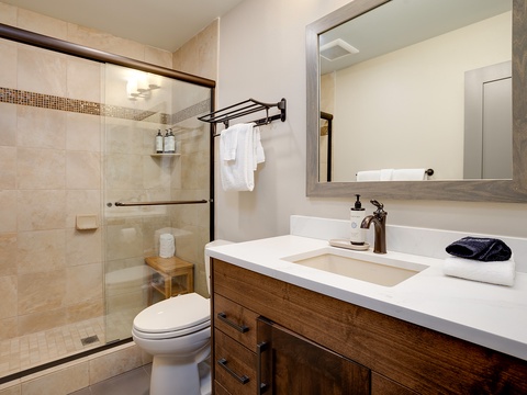 Step into your spa-like bathroom where warm beige tones and sleek fixtures invite you to unwind. Fresh towels await, and the walk-in shower offers a serene start to your day.