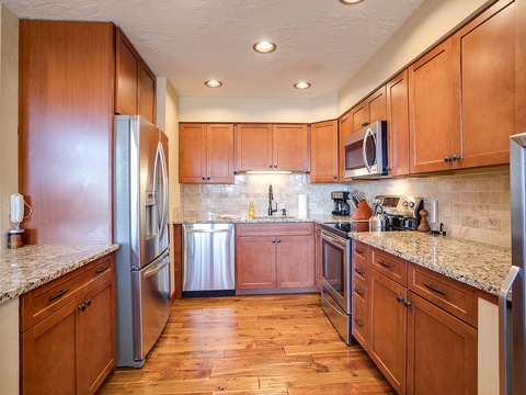 Step into your fully-equipped kitchen with granite countertops, stainless steel appliances, and warm wood cabinetry. Everything you need to prepare delicious meals during your stay.
