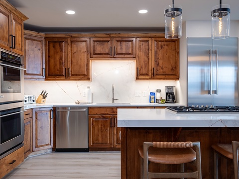 Your home-away-from-home features a fully equipped gourmet kitchen with rich wood cabinetry, sleek marble countertops, and stainless steel appliances—perfect for preparing your favorite meals.