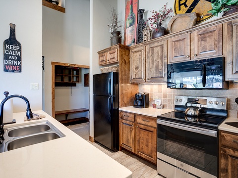 Your fully equipped kitchen features rustic wood cabinetry, modern appliances, and charming details—perfect for preparing meals at home after exploring the area.
