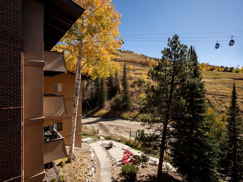 Scenic autumn mountain landscape with ski gondolas overhead and vibrant golden foliage framing the hillside. Property located in peaceful natural surroundings with seasonal access to mountain recreation.