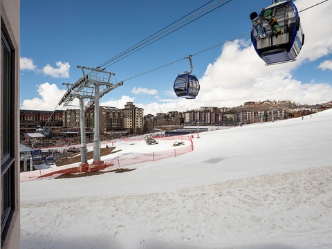 Prime ski village location with gondola access. Snow-covered slopes meet base area amenities—restaurants, shops, and lodging steps from lift lines in a scenic mountain setting.