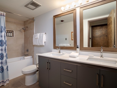 Your private bathroom features dual vanities, soft lighting, and a tub-shower combo where you can unwind after a day exploring.