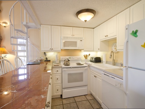 Your fully equipped kitchen invites you to prepare meals together, with bright white cabinetry, modern appliances, and a cozy breakfast table—perfect for morning coffee or family dinners.