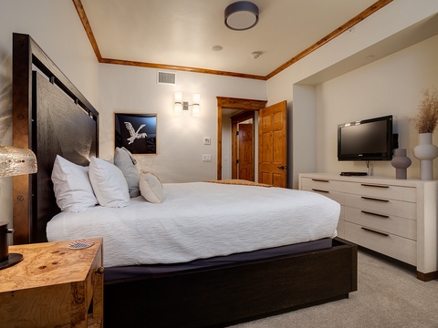 Sink into the plush king bed and enjoy your own flat-screen TV. The warm wood tones and soft lighting create a cozy retreat after a day of adventure.