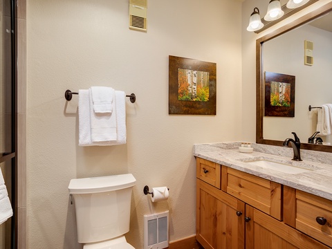 Refresh in your private bathroom with granite countertops, warm wood cabinetry, and soft lighting. Fresh towels and thoughtful touches await your arrival.