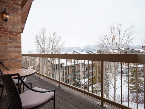 A private balcony overlooking snow-dusted rooftops and mountain peaks—a peaceful retreat where you can sip morning coffee or unwind with winter views stretching across the scenic neighborhood.