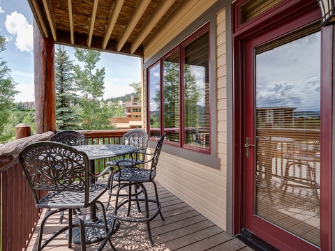 Step onto your private balcony and savor mountain air with morning coffee at a cozy bistro table surrounded by alpine greenery and distant peaks.