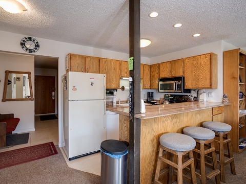 Your fully-equipped kitchen awaits with everything you'll need—stove, microwave, coffee maker, and ample counter space for preparing meals during your stay.