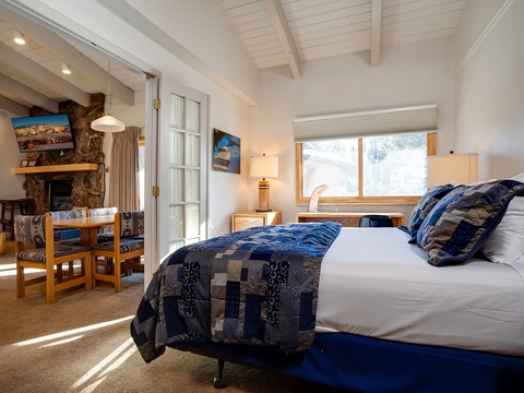 Sink into crisp linens under vaulted ceilings, where your mountain-view window frames snowy slopes and the bedroom's cozy fireplace beckons after a day outdoors.