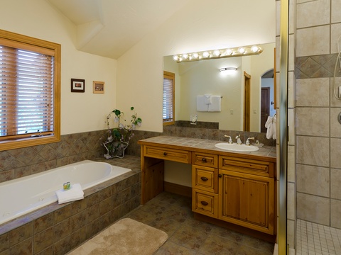 Unwind in your private spa-like bathroom featuring a deep soaking tub, spacious walk-in shower, and plenty of counter space for your comfort and convenience.