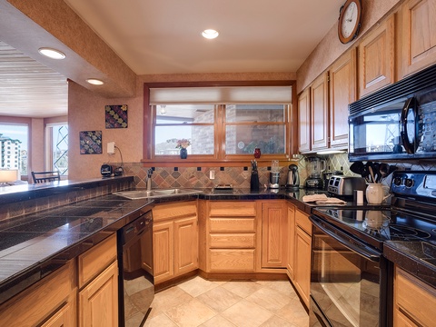 Your fully equipped kitchen features granite countertops, modern appliances, and plenty of prep space—perfect for cooking your favorite meals while enjoying natural light from the window above the sink.
