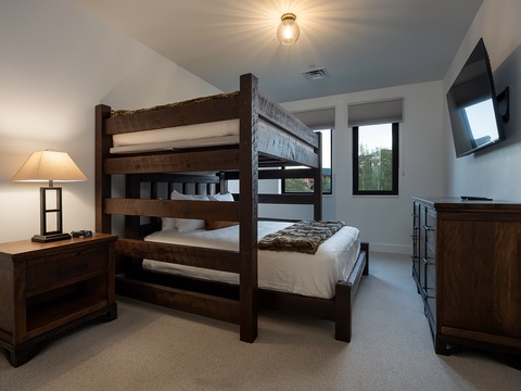 Perfect for families or friends, this cozy bedroom features a sturdy bunk bed and extra sleeping space. You'll enjoy views of the surrounding greenery through large windows, plus a wall-mounted TV for downtime.