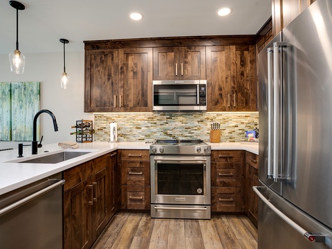 Your fully equipped kitchen features rich wood cabinetry, stainless steel appliances, and a gleaming countertop—perfect for preparing home-cooked meals during your getaway.