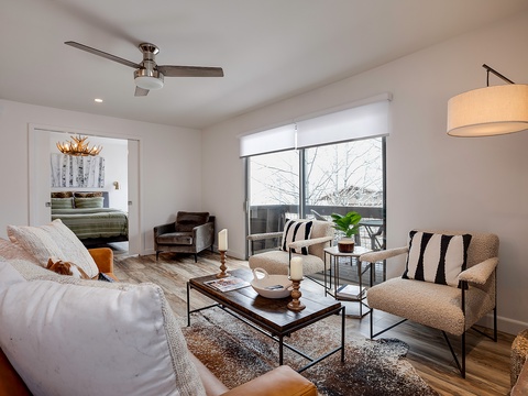 Unwind in this bright, beautifully styled living space where plush seating and warm textures invite you to relax. Natural light pours through expansive windows, framing peaceful winter views that enhance your getaway experience.