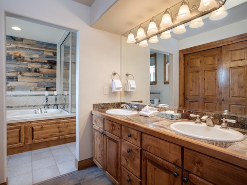 Unwind in your private spa-like bathroom with a soaking tub, dual vanities, and warm rustic wood accents. Fresh towels and soft lighting await your arrival.