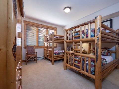 Your little adventurers will love this cozy bunk room with its rustic log beds and playful charm, making bedtime feel like a cabin getaway.