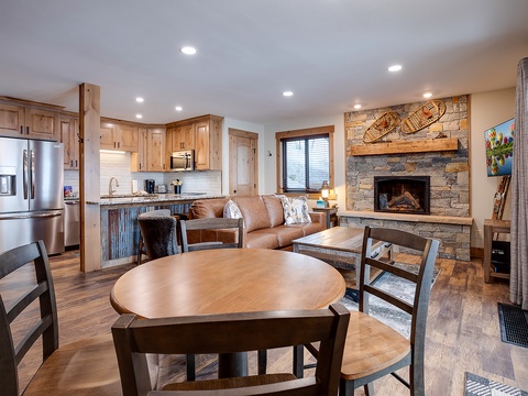 Gather around the table after a day on the slopes, then relax by the stone fireplace. Your open-concept retreat blends rustic charm with modern comforts for ultimate mountain getaway vibes.