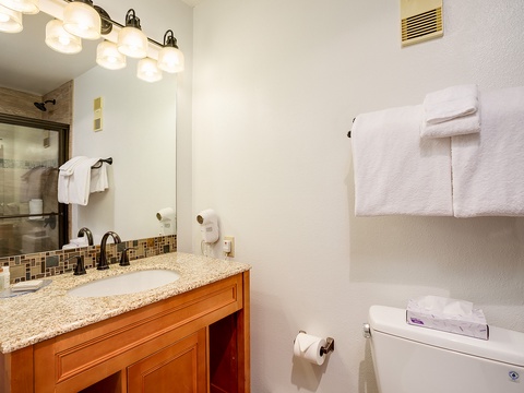 Freshen up in your bright, well-appointed bathroom with a granite vanity, stylish tile accents, walk-in shower, and plush towels waiting for you.