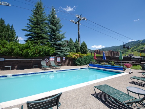 Sparkling pool nestled among evergreens with mountain vistas—your summer basecamp for alpine adventures. Lounge poolside under vibrant umbrellas and soak in the fresh air and views.