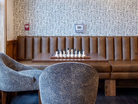 Settle into plush seating where you can strategize over a game of chess, surrounded by warm textures and modern design that invite relaxation.
