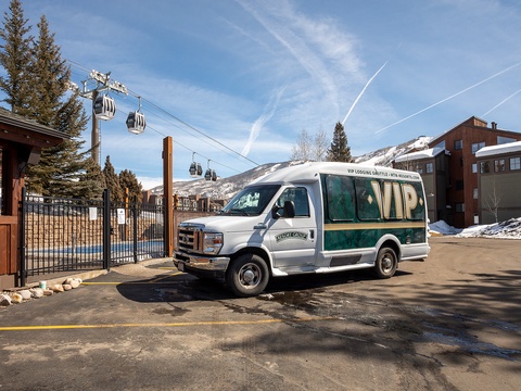 VIP shuttle service positioned near the gondola base, providing convenient transportation to the ski area and surrounding mountain facilities during winter season.