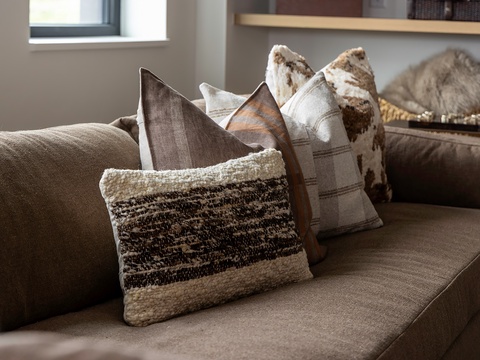 Sink into the plush sofa adorned with thoughtfully layered throw pillows and a cozy blanket—your perfect spot to unwind and relax in comfort.