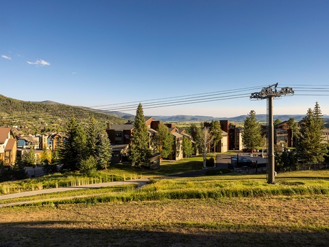 Mountain resort community nestled among evergreens and rolling hills under a clear blue sky, showcasing the scenic alpine setting and surrounding landscape.