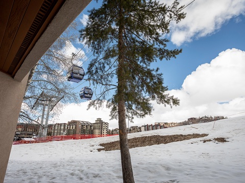 Ski-in access via chairlift connects this property to snowy slopes, surrounded by alpine village buildings and natural mountain scenery.