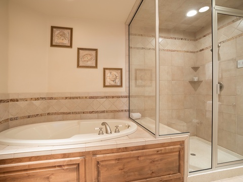 Unwind in your spa-like bathroom, featuring a deep soaking tub and separate walk-in shower with elegant tile work and built-in shelving for your essentials.