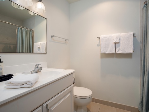 Step into your bright, serene bathroom with fresh towels waiting, a spacious vanity, and a soothing palette that invites you to relax after exploring.