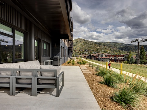Spacious outdoor patio with modern seating where you can take in the surrounding mountain scenery and neighborhood charm from the comfort of your private space.