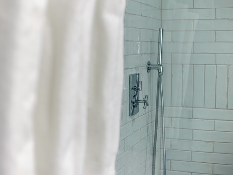 Refresh with a soothing rinse in your sleek subway-tiled shower, designed with modern fixtures and clean lines for a spa-like retreat.