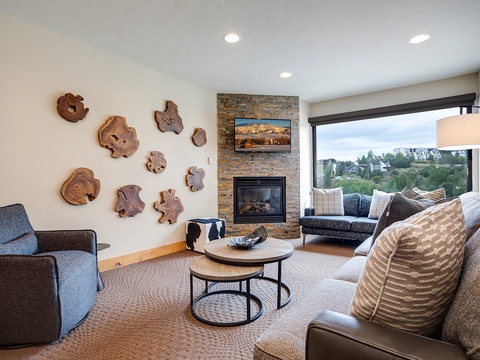 Sink into plush seating in your living room and enjoy the warmth of the fireplace while soaking in scenic hillside views through floor-to-ceiling windows.