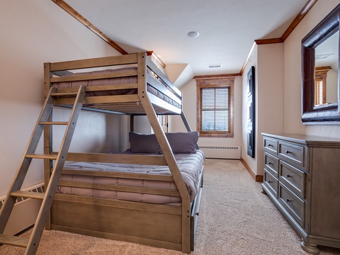 Snuggle into comfortable bunk beds after a day of adventure, with plenty of dresser space for your belongings and soft natural light through the window.