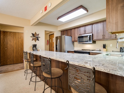 Gather around the spacious granite island where you can prep meals, share stories, or enjoy morning coffee together in this beautifully appointed kitchen.