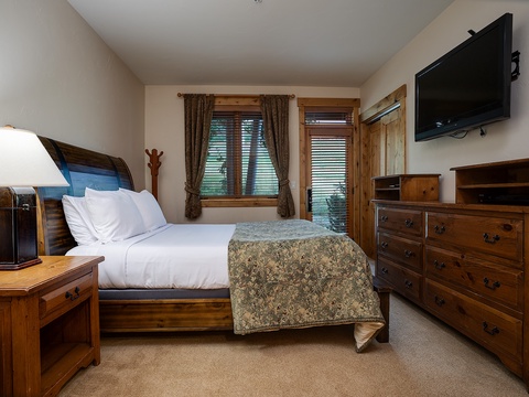 Drift off to sleep in your cozy retreat, featuring warm wood furnishings, plush bedding, and all the comforts you need for a restful stay.