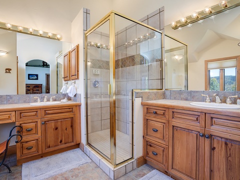 Dual vanities and a spacious walk-in shower await, offering comfort and convenience in your private retreat after a day of mountain adventure.