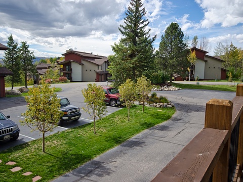 A well-maintained resort community nestled in a scenic mountain setting, featuring landscaped grounds, ample parking, and residential-style buildings surrounded by mature evergreen and deciduous trees.