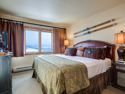 Sink into your cozy bed and wake up to sweeping lake views through large windows. Vintage skis add mountain charm, while warm lamps create a relaxing, homey atmosphere.